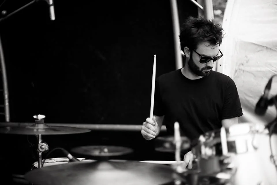 Antoine Valvin à la batterie sur scène, en noir et blanc